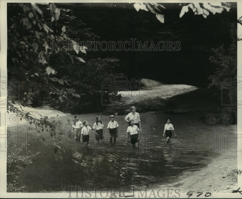 1969 Girl Scouts and counselor in water of Bogue Falaya - Historic Images