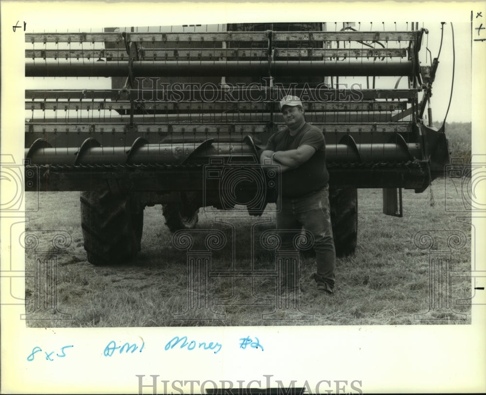 1990 Press Photo Mike Habetz in a farm field with a combine for harvesting. - Historic Images