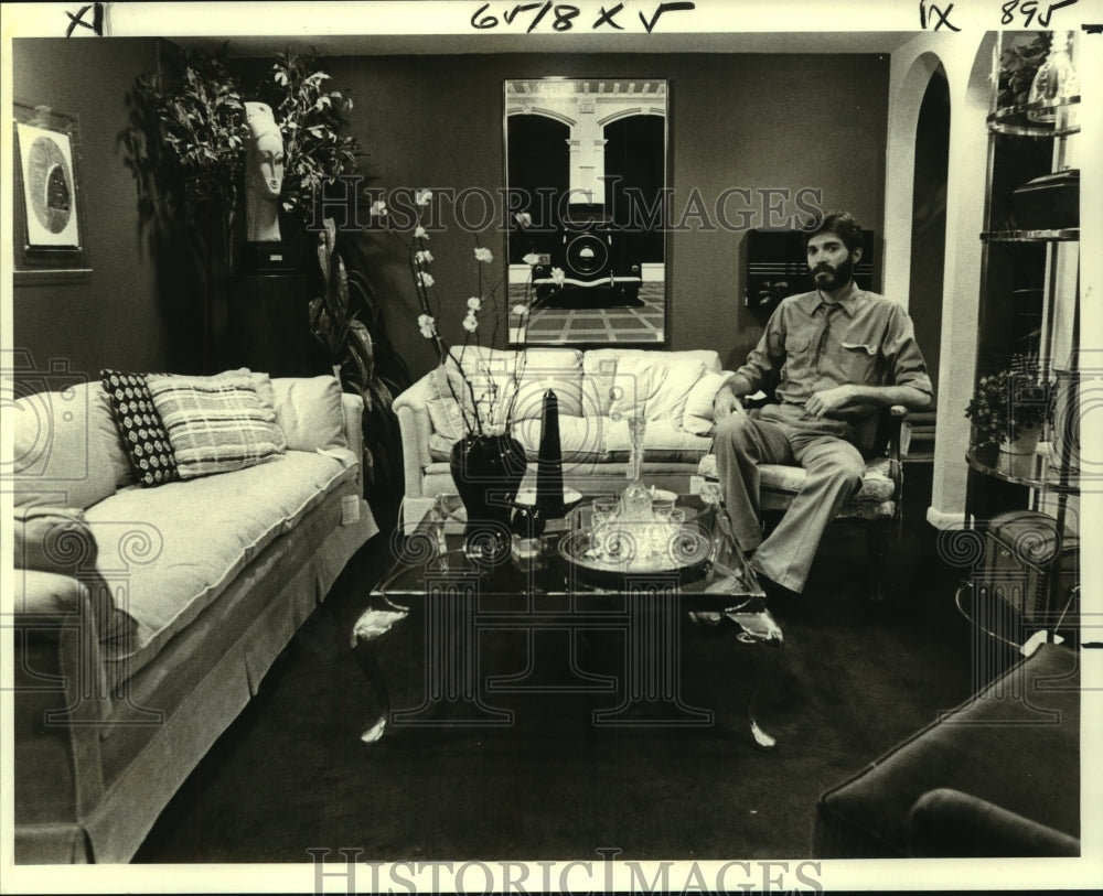 1979 Press Photo Designer William Godwin relaxes among red walls and painting - Historic Images