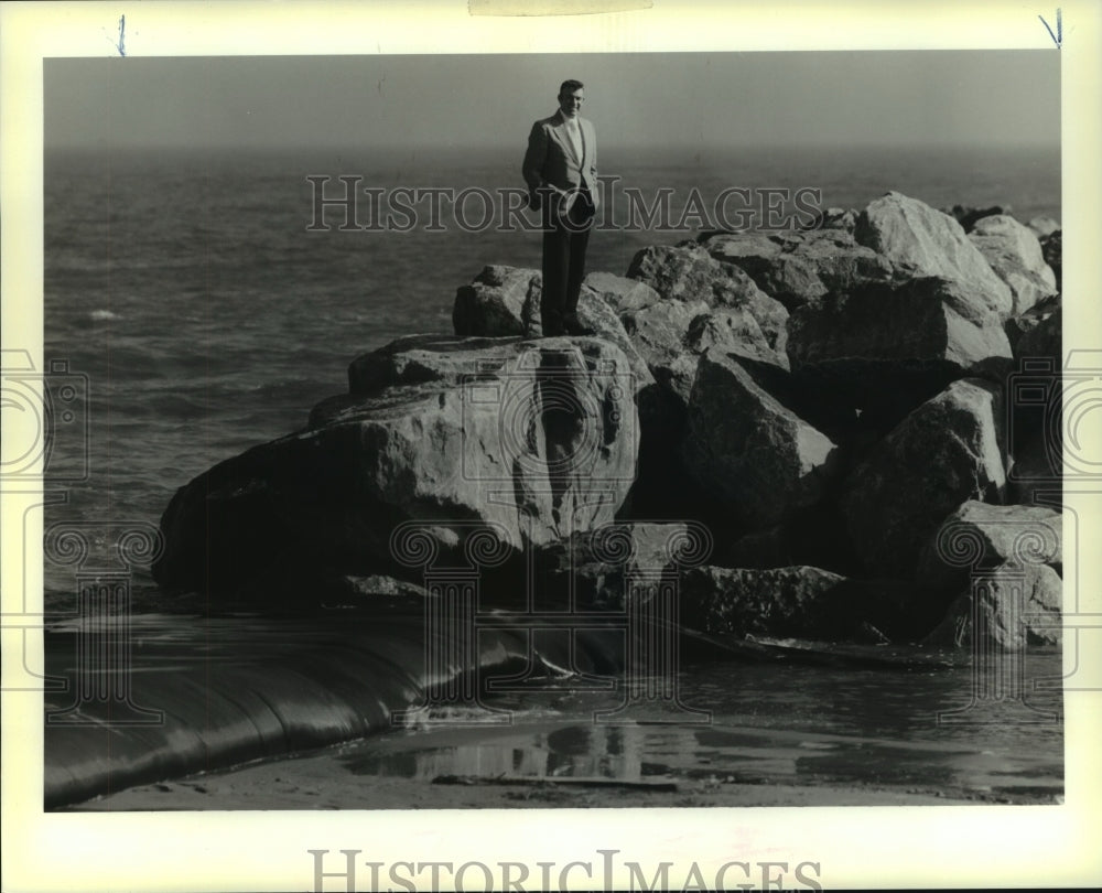 1990 Press Photo Grand Isle Mayor Andy Valence atop boulders at the offshore - Historic Images