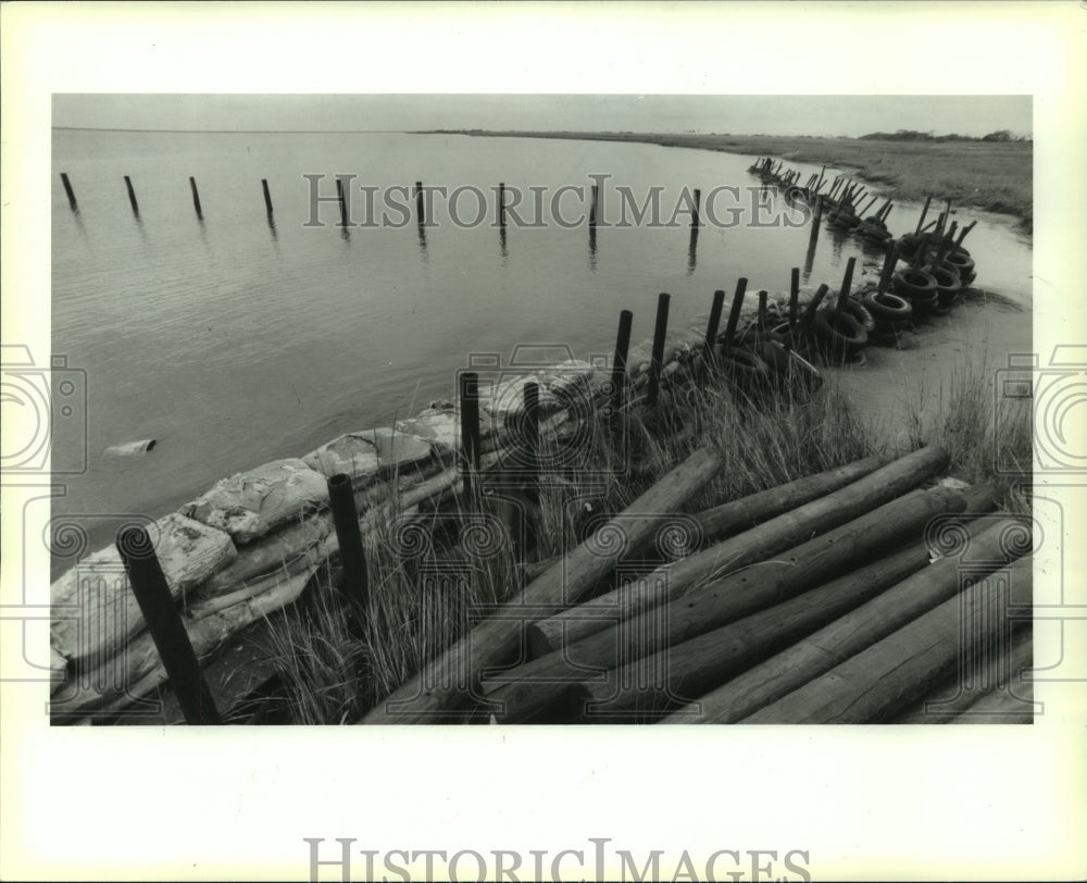 1991 Press Photo Tire &amp; sandbag levee on the Bay Caminada, Grand Isle - Historic Images