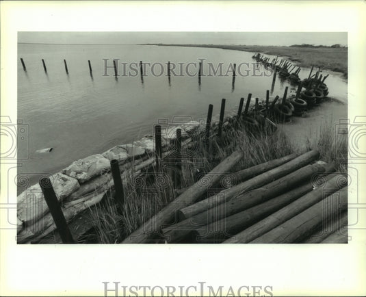 1991 Press Photo Tire & sandbag levee on the Bay Caminada, Grand Isle - Historic Images