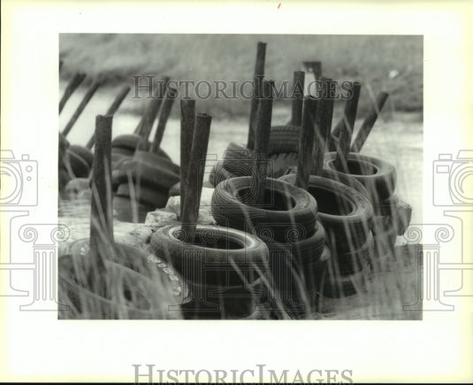 1991 Press Photo Tire & sandbag levee on the Bay Caminada, Grand Isle - Historic Images