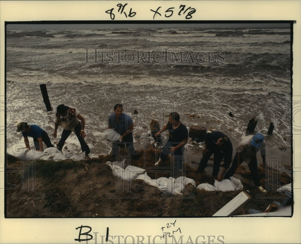 1989 Volunteers pass sandbags at Wateredge Apartments on Grand Isle - Historic Images