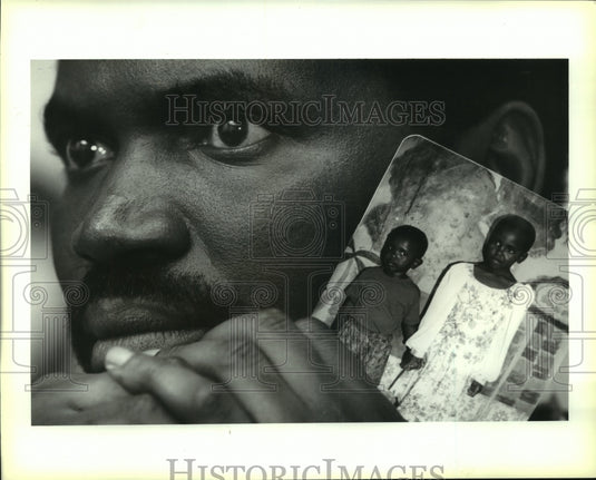 1994 Press Photo Celestin Hakirvwizera holds a photo of his children - Historic Images