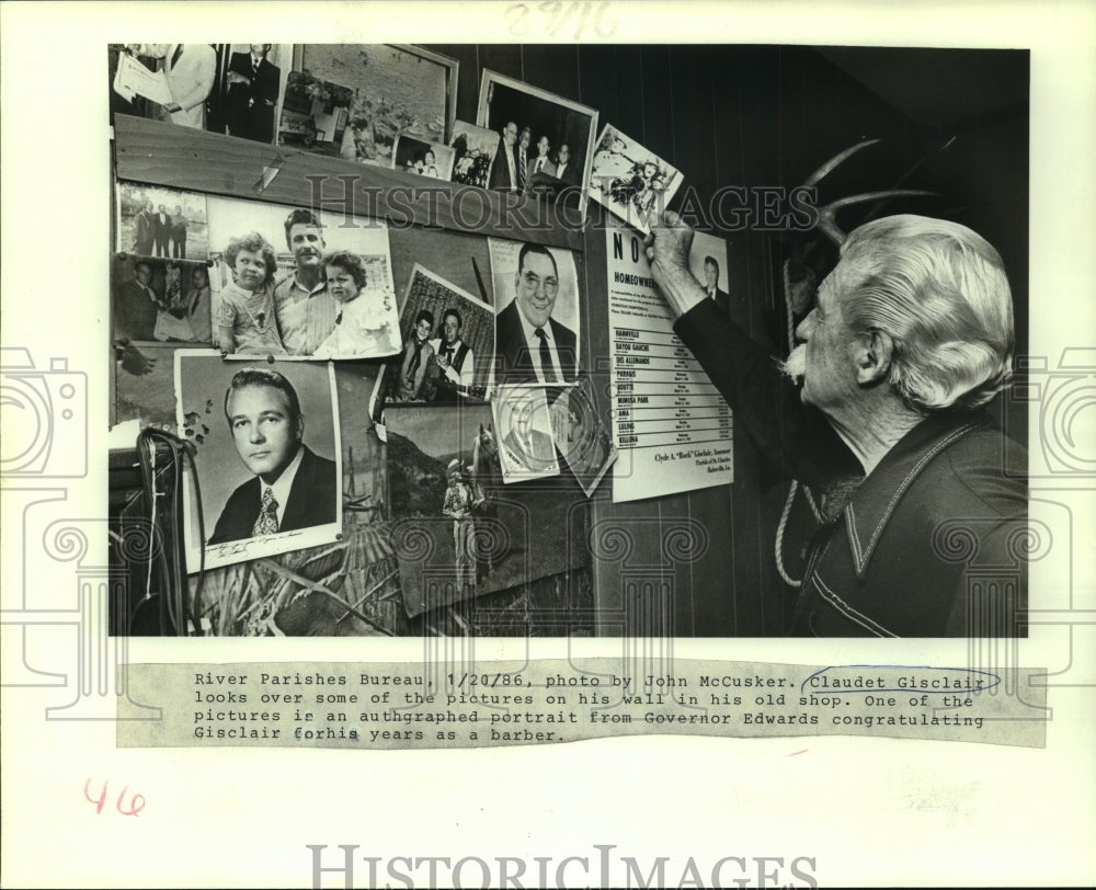 1986 Press Photo Claudet Gisclair looks over some pictures in his old shop - Historic Images