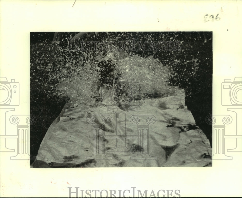 1982 Press Photo Counselor A.J. Hingle slides through water at Girod Playground - Historic Images