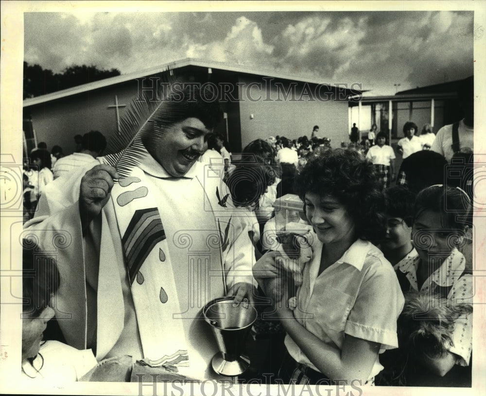 1983 Press Photo Fr. Frank J. Giroir blesses a pet Rabbit at Resurrection school - Historic Images