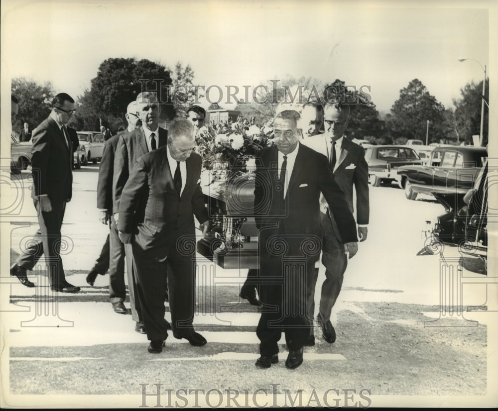 Press Photo Officials carry a coffin during burial ceremonies - Historic Images