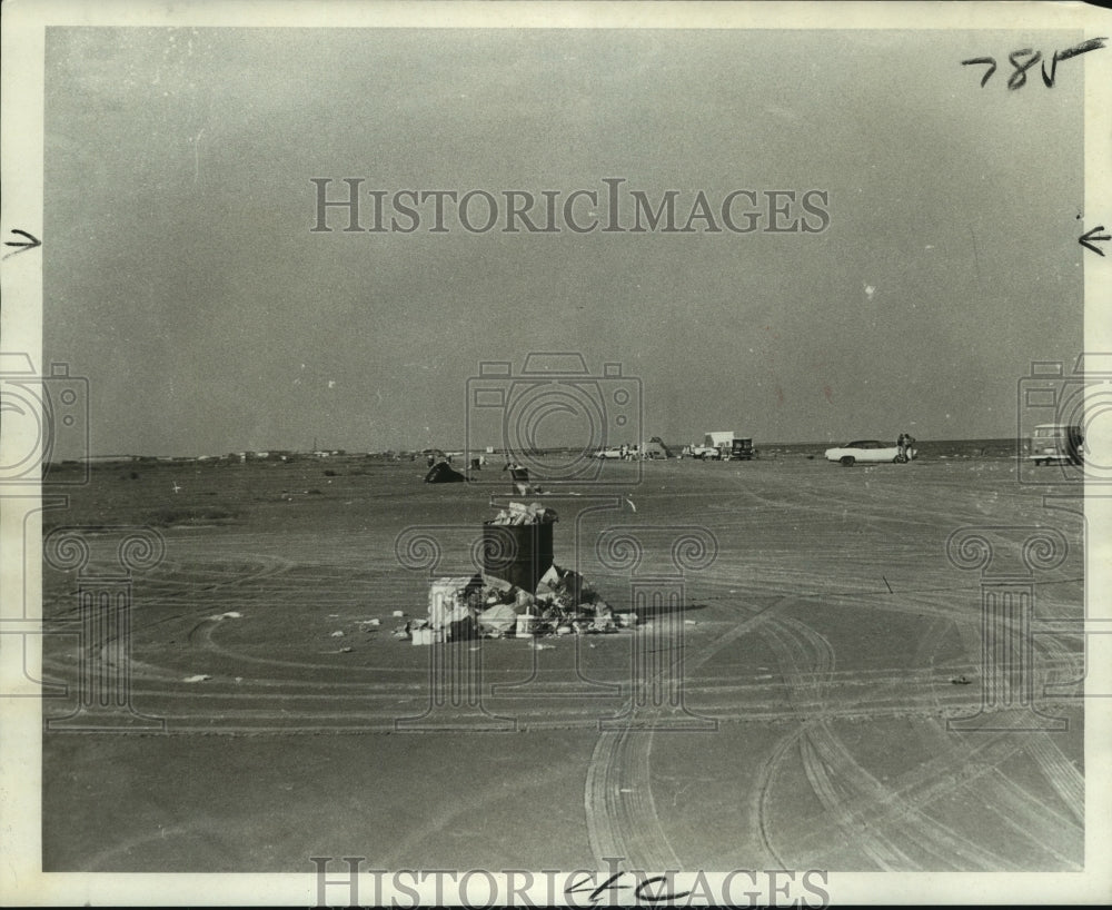 1970 Overflowing trash cans decorate Grand Isles white sands - Historic Images