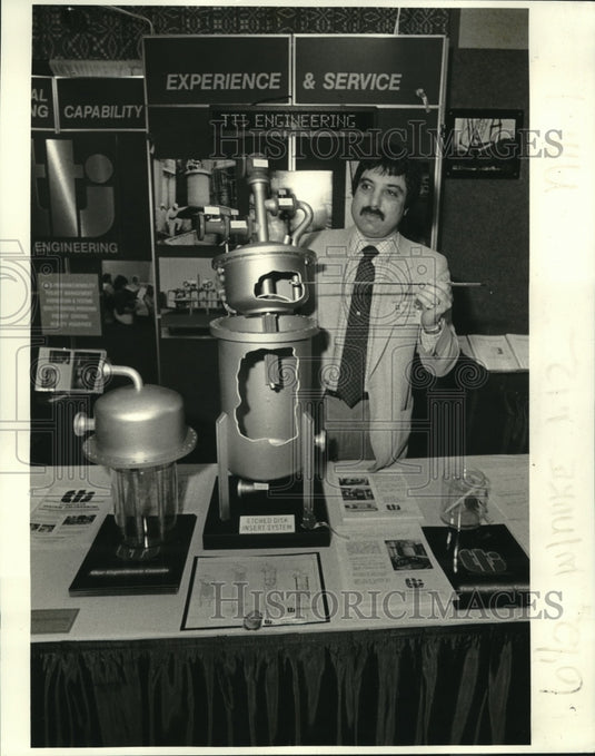 1984 Press Photo Patrick Gillis explains the etched disc system at Hilton Hotel. - Historic Images