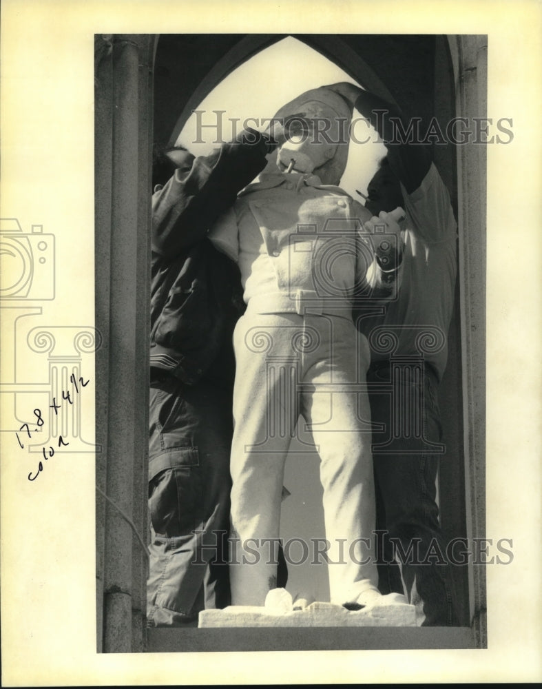 1992 Press Photo Group replaces head on fireman statue in Greenwood Cemetery - Historic Images