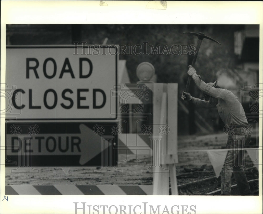 1989 Press Photo Charlie Campbell swings his pick-axe on Fourth Street in Gretna - Historic Images