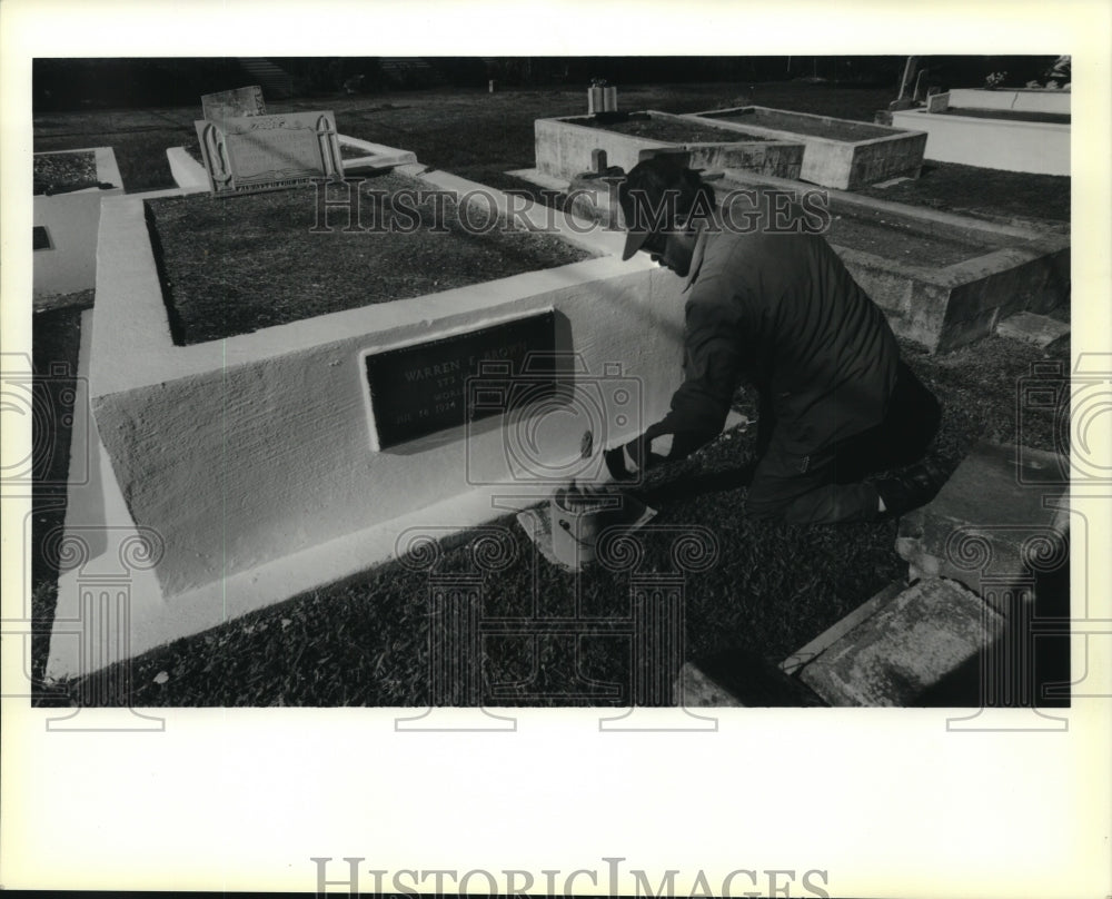 1989 Press Photo Derrick Smith cleans graves at Greenwood Cemetery in Slidell - Historic Images