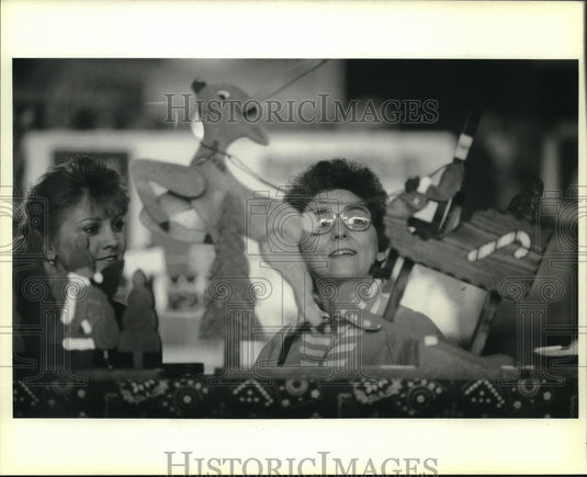 1998 Press Photo Beverly Ross looks at Christmas wood works, New Orleans - Historic Images