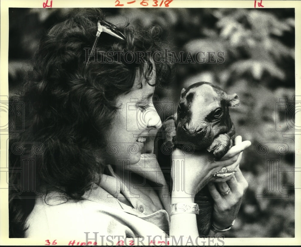 1987 Press Photo Linda Sanders holds &quot;Nessie&quot;, a rare pygmy hippo at the zoo - Historic Images