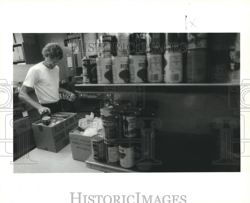 1993 Gretna Food Bank Volunteer Bruce Bartholomew packing food - Historic Images