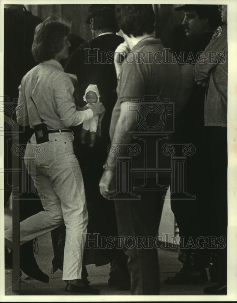 1986 Press Photo A NOPD officer carries Linda Hanchette&#39;s doll after surrender - Historic Images