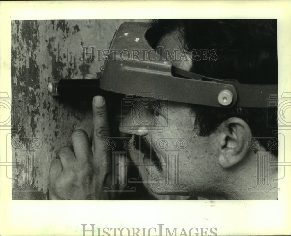 1988 Matthew Mosca takes a look at paint on Hermann-Grimma House - Historic Images