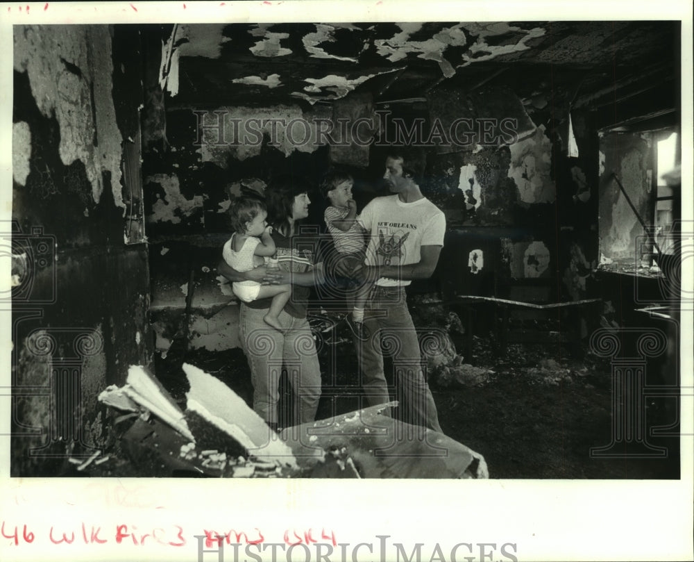 1987 Press Photo Gretna couple &amp; children stand inside their burned apartment - Historic Images