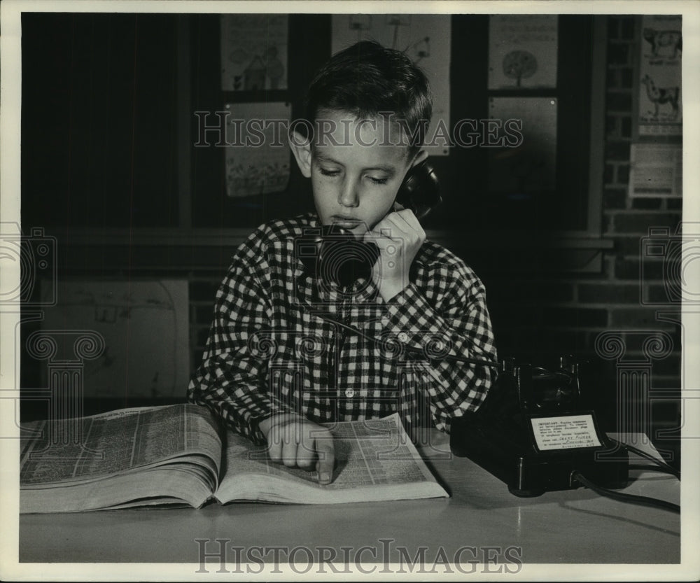 1954 Press Photo Daniel Dix use telephone directory while calling at Hart School - Historic Images