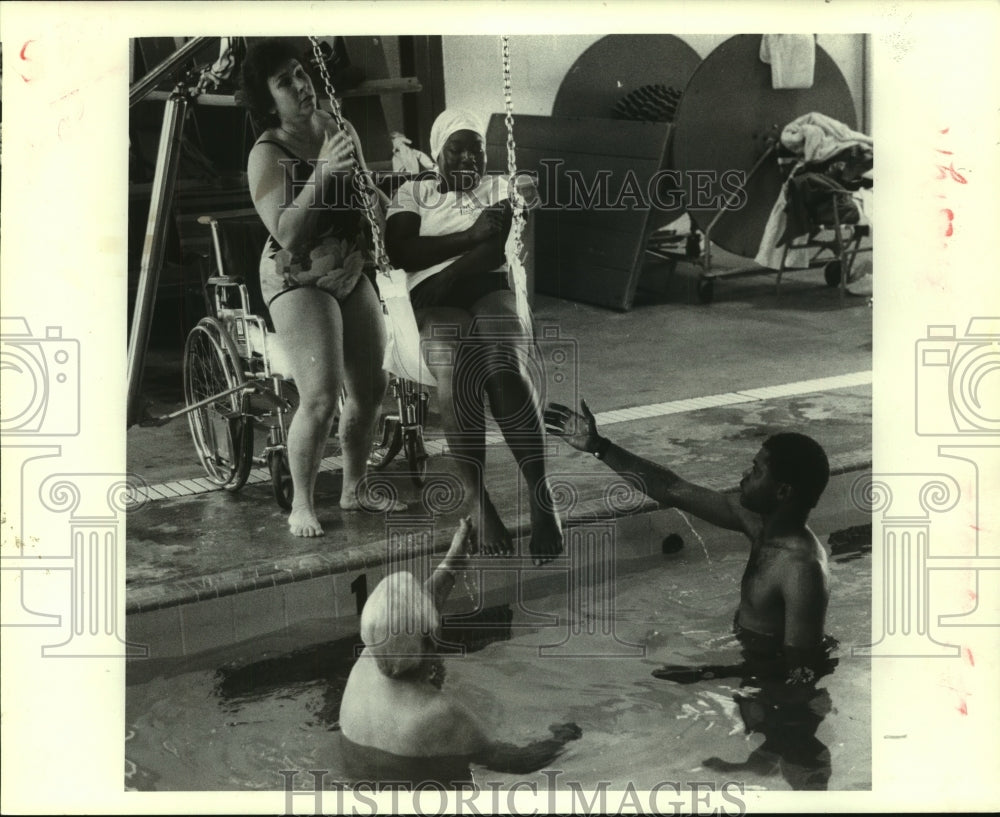 1985 Ray Aguillard lowers handicapped Dorris Warren in the pool - Historic Images