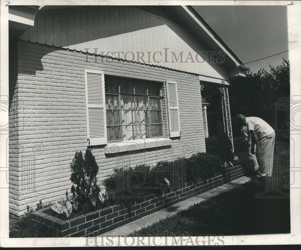 1967 Mrs. Haslauer painting the exterior of her Metairie home - Historic Images