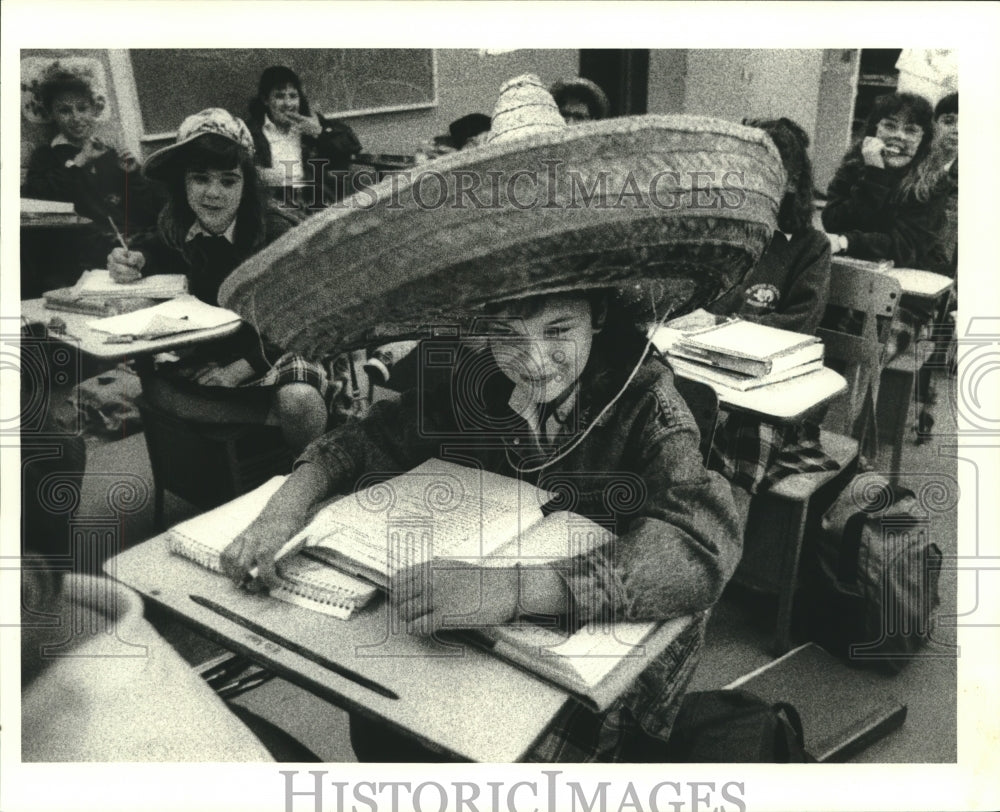 1989 St. Peter School student Melissa Torres wears sombrero in class - Historic Images