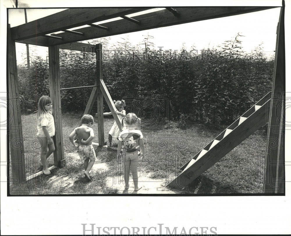 1987 Children play on playground behind apartment in Harvey - Historic Images