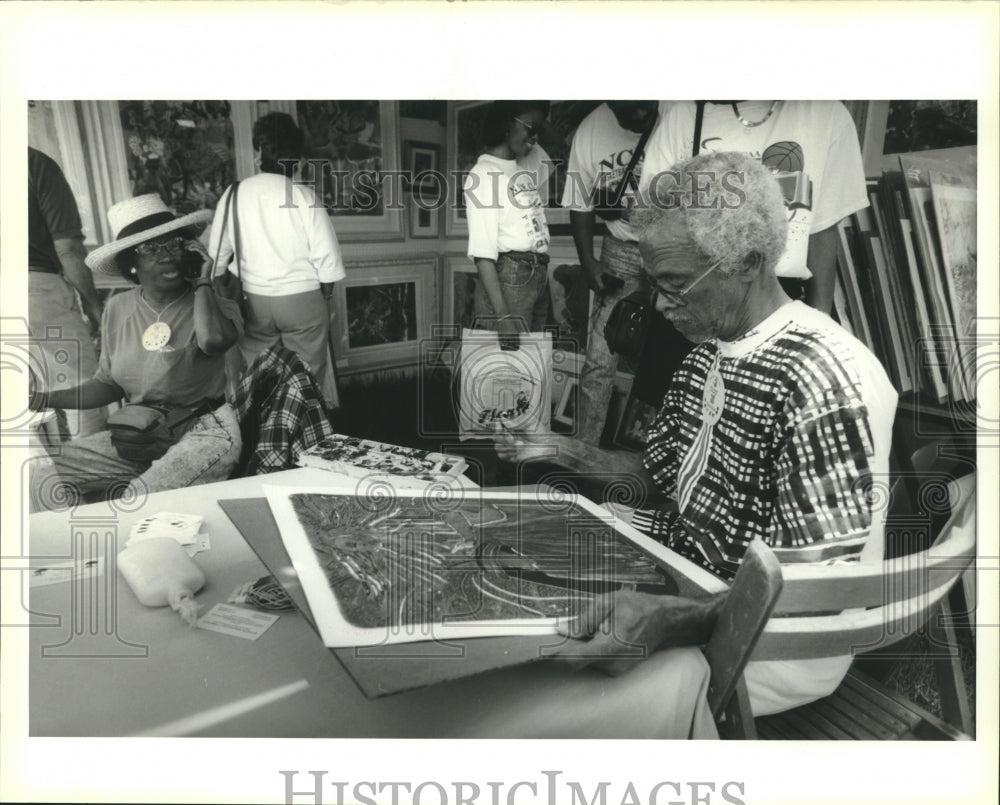 1993 Edwin Harris works on a painting at his booth in Congo Square - Historic Images