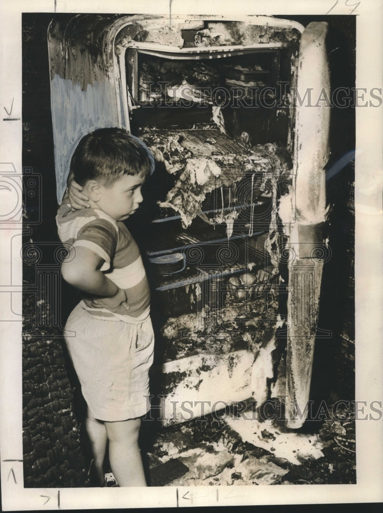 1955 Press Photo George Hingle looking at their family's burned refrigerator - Historic Images