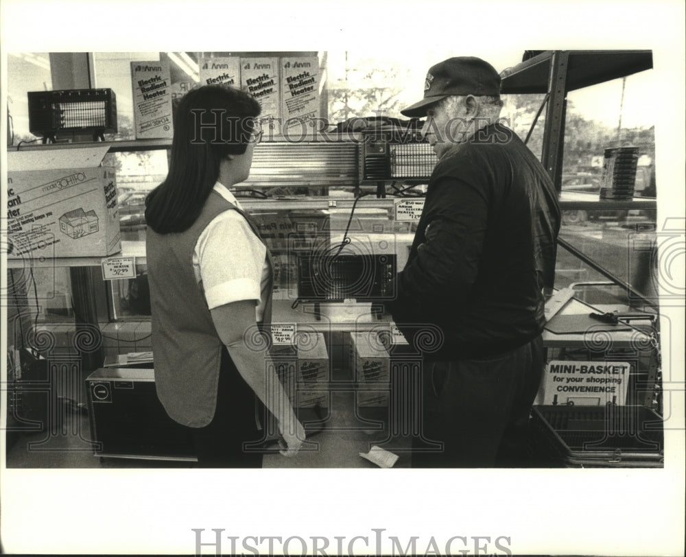 1988 Press Photo Sherran Cannon helps Harrold Miller with electric heaters - Historic Images