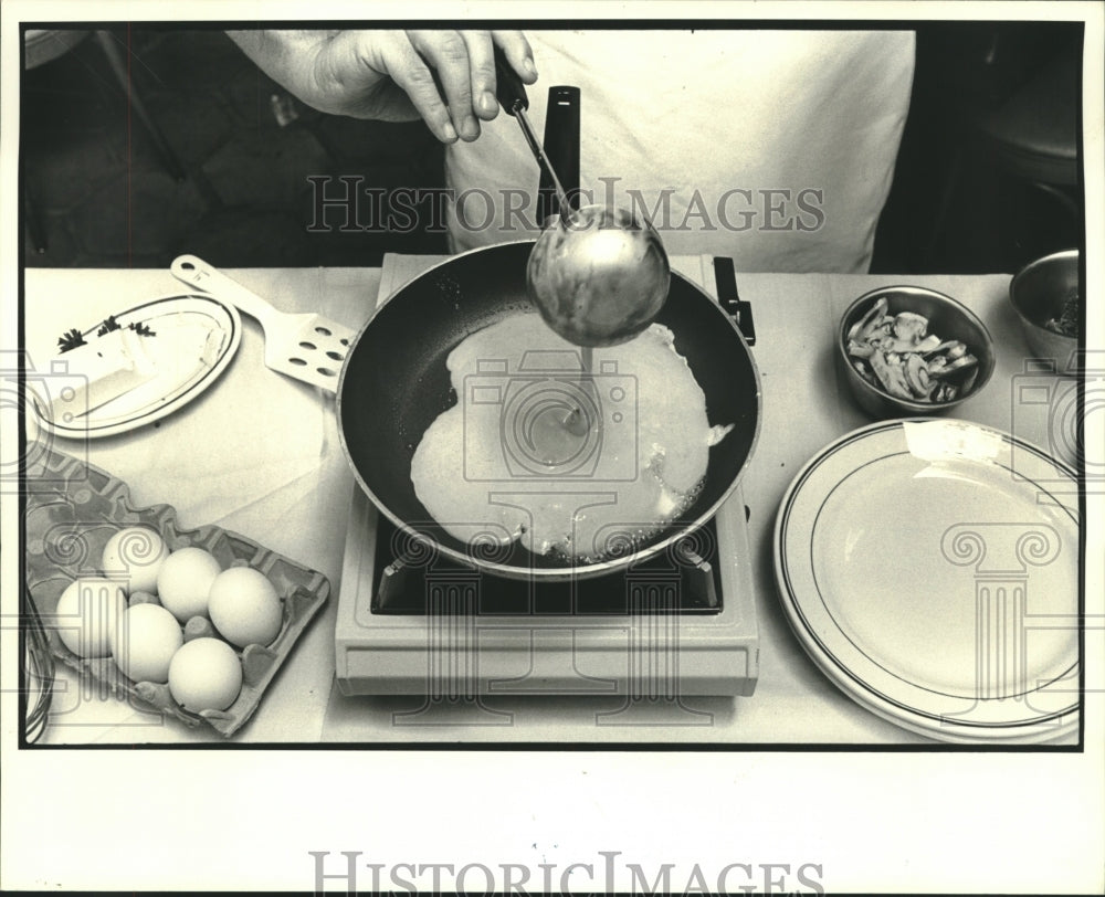 1984 Press Photo Howard Helmer creates an omelet at 4141 St. Charles - nob33943 - Historic Images