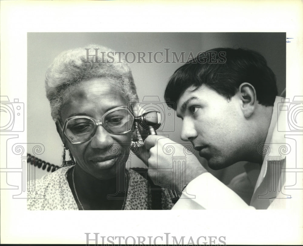 1990 Press Photo Dr. Christopher W. Ives examines the ear of Hattie Mae Black - Historic Images