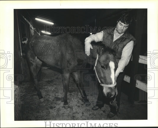 1989 Press Photo Belle Chasse veterinarian Stephen Hebert pets "Panama Jack" - Historic Images