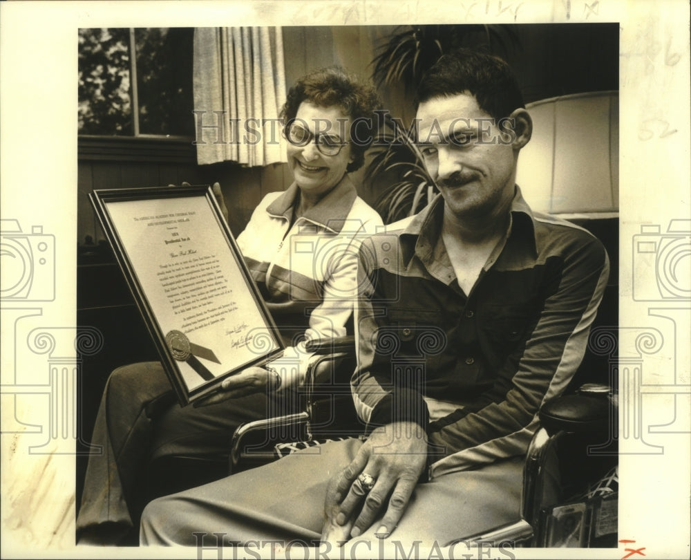 1979 Press Photo Glen Paul Hebert looks at his award, held by his mother. - Historic Images