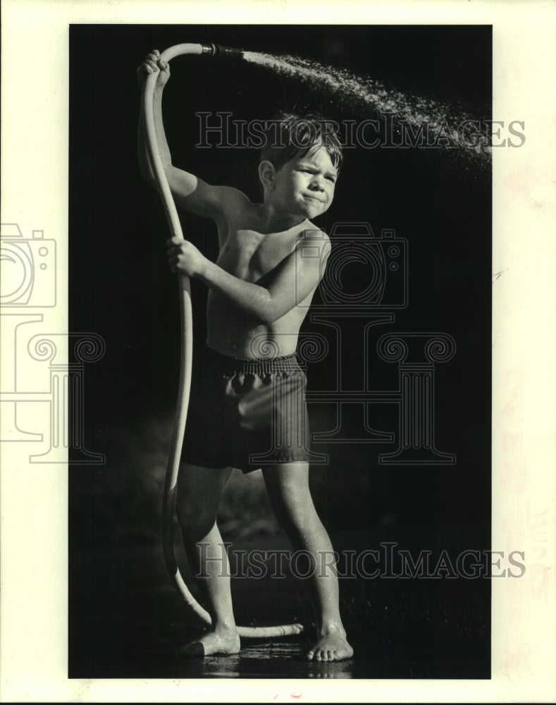 1988 Press Photo Jody Honold sprays his brother with a hose in Chalmette - Historic Images