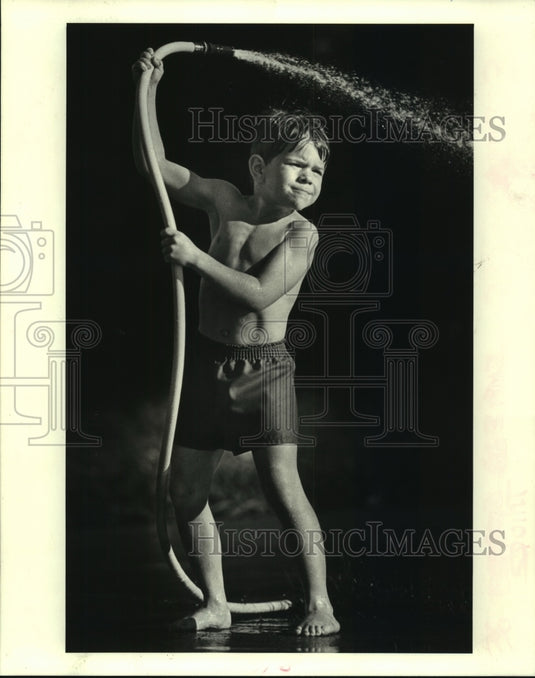 1988 Press Photo Jody Honold sprays his brother with a hose in Chalmette - Historic Images