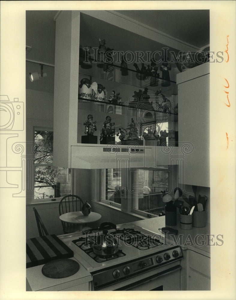 1987 Press Photo Folk art is displayed on a glass shelving unit in a kitchen - Historic Images