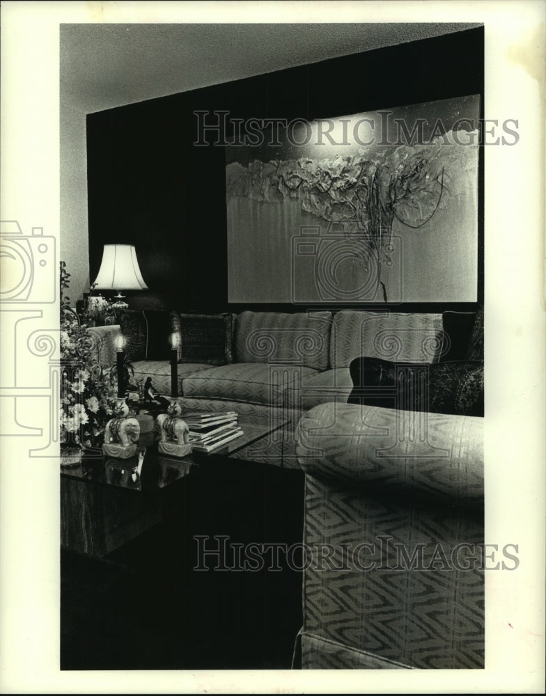 1989 Living room designed with a dark green wall and piece of art. - Historic Images