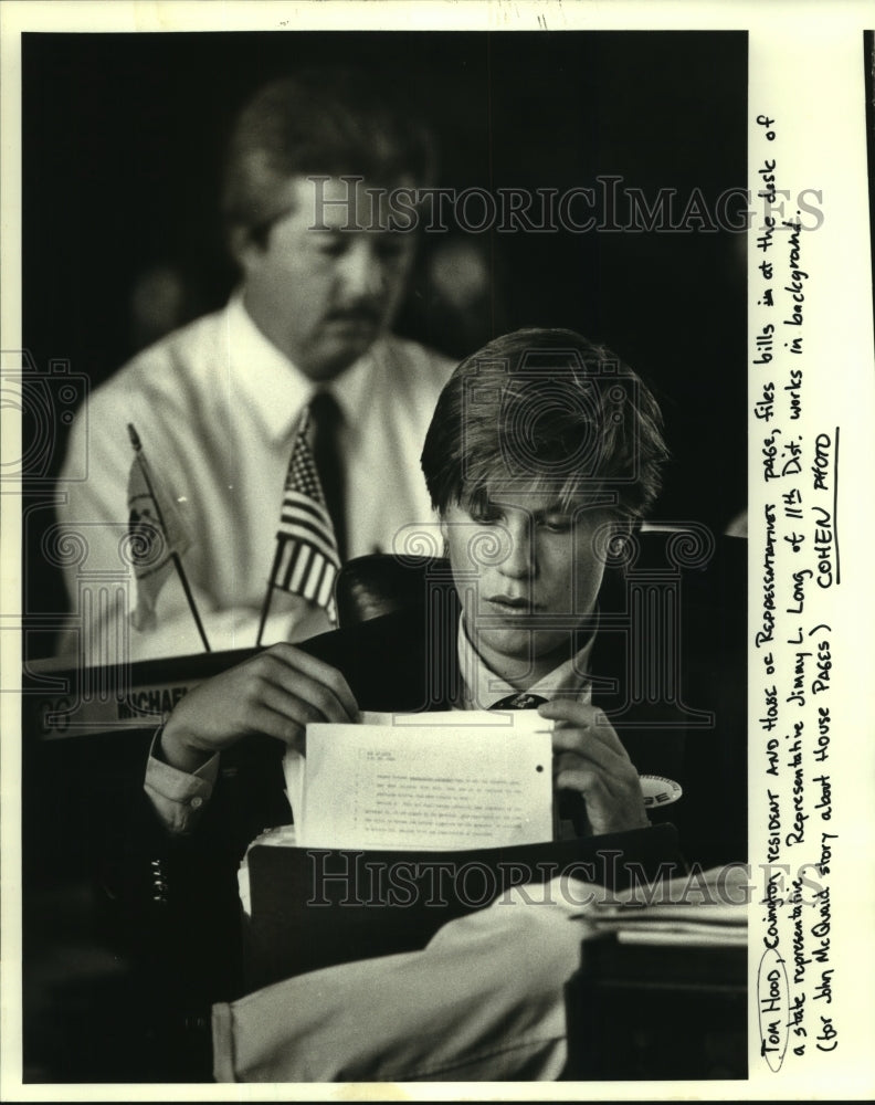 1987 Press Photo House of Representatives page Tom Hood files bills at a desk - Historic Images