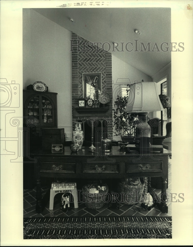 1986 Press Photo Toys are neatly stashed beneath an antique table - Historic Images