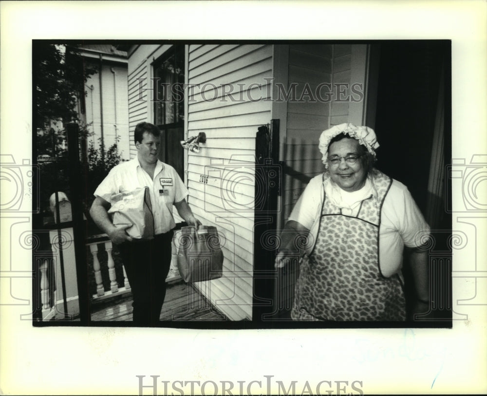 1991 Press Photo Senior Alice Porter opens gate to let Bryan Smith deliver order - Historic Images