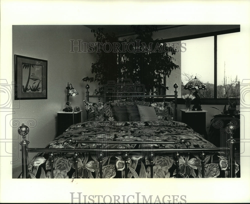 1990 Press Photo A large bed is cater-cornered &amp; backs up to a wooded view - Historic Images