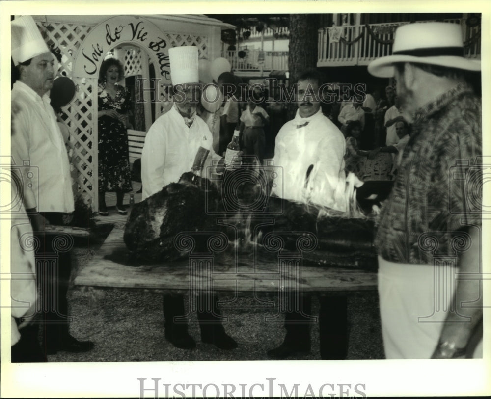 1990 Press Photo Chef Jack Hines prepares roasted pig at Joie de Vie Balle event - Historic Images