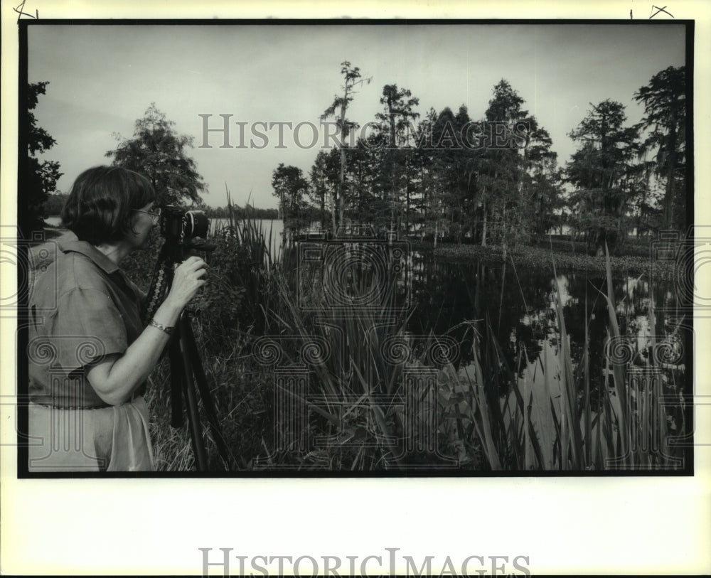 1991 Press Photo Gail Hood, Covington artist, photographs a scene at Pine Island - Historic Images