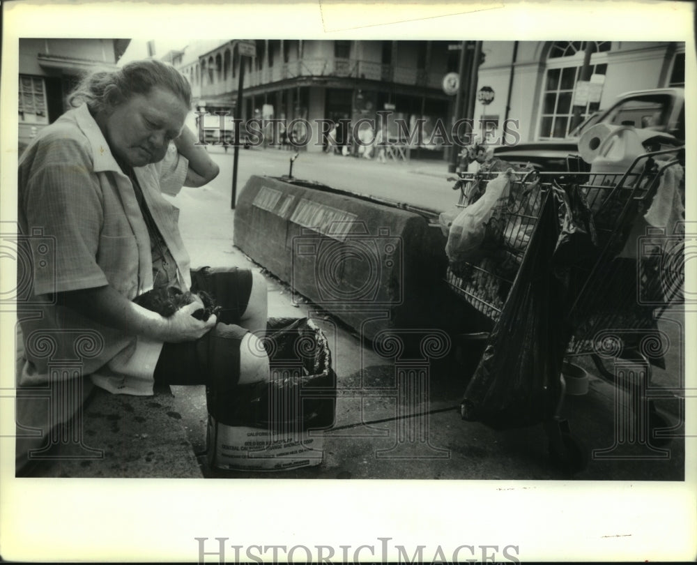 1989 Press Photo Homeless Anita Cole finds plastic bag to cool aching feet - Historic Images