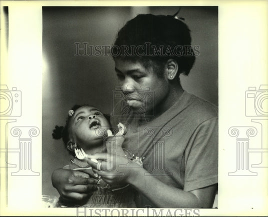 1988 Press Photo Christine Harris feeding sister Janice Harris - Historic Images