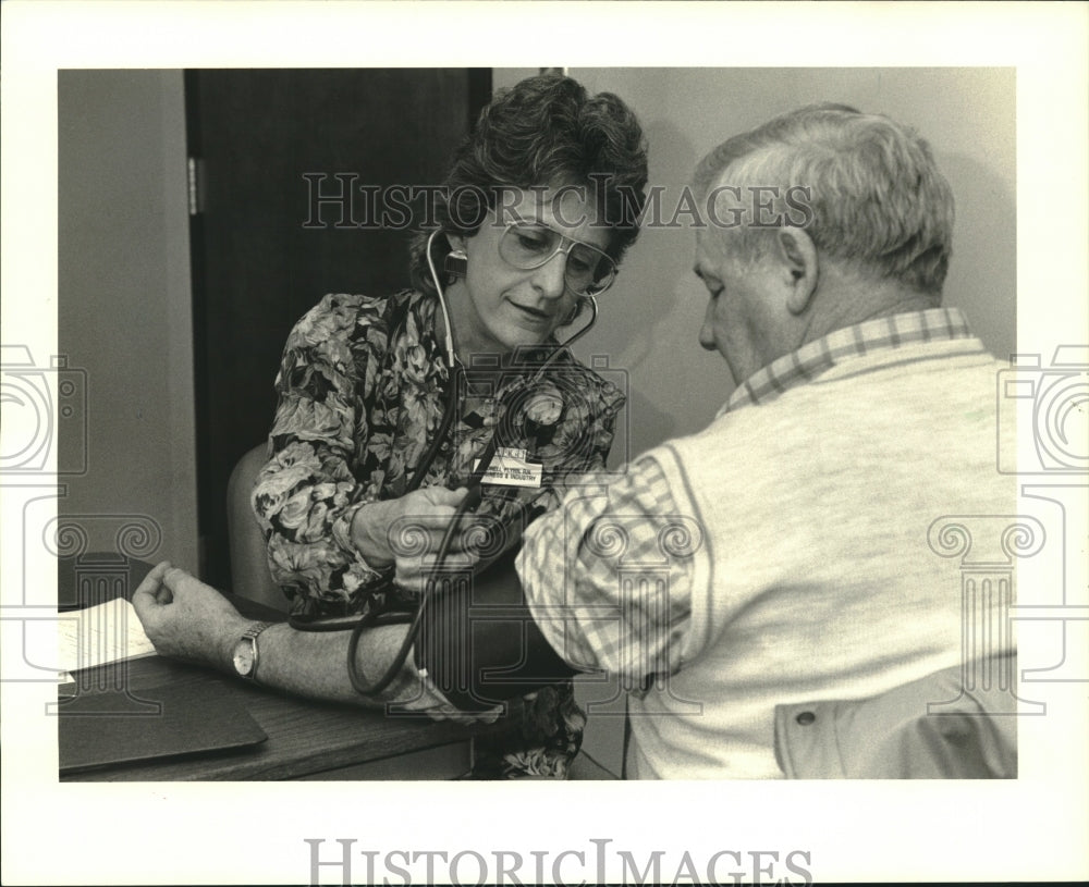 1989 Press Photo Hypertension - Jonell Flynn checks patient, Joe Yenni building - Historic Images