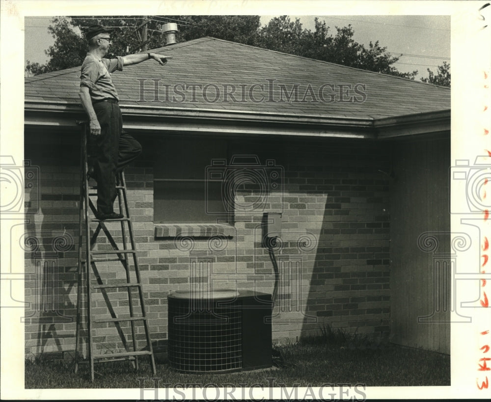 1980 Press Photo Wiltz Hymel looks over roof at his 1008 Carnation St. home - Historic Images